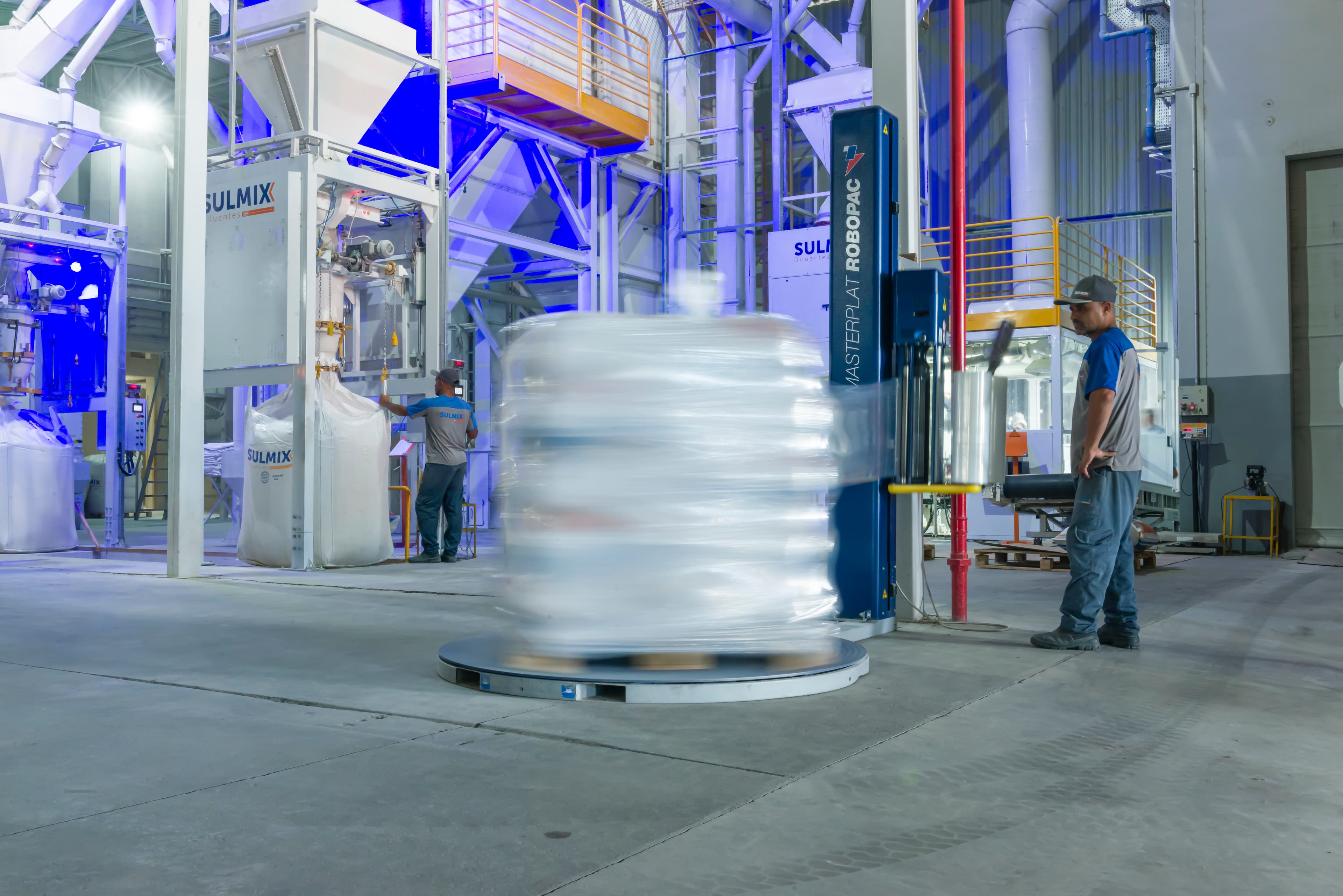 Paletizadora e operadores na linha de produção da Sulmix